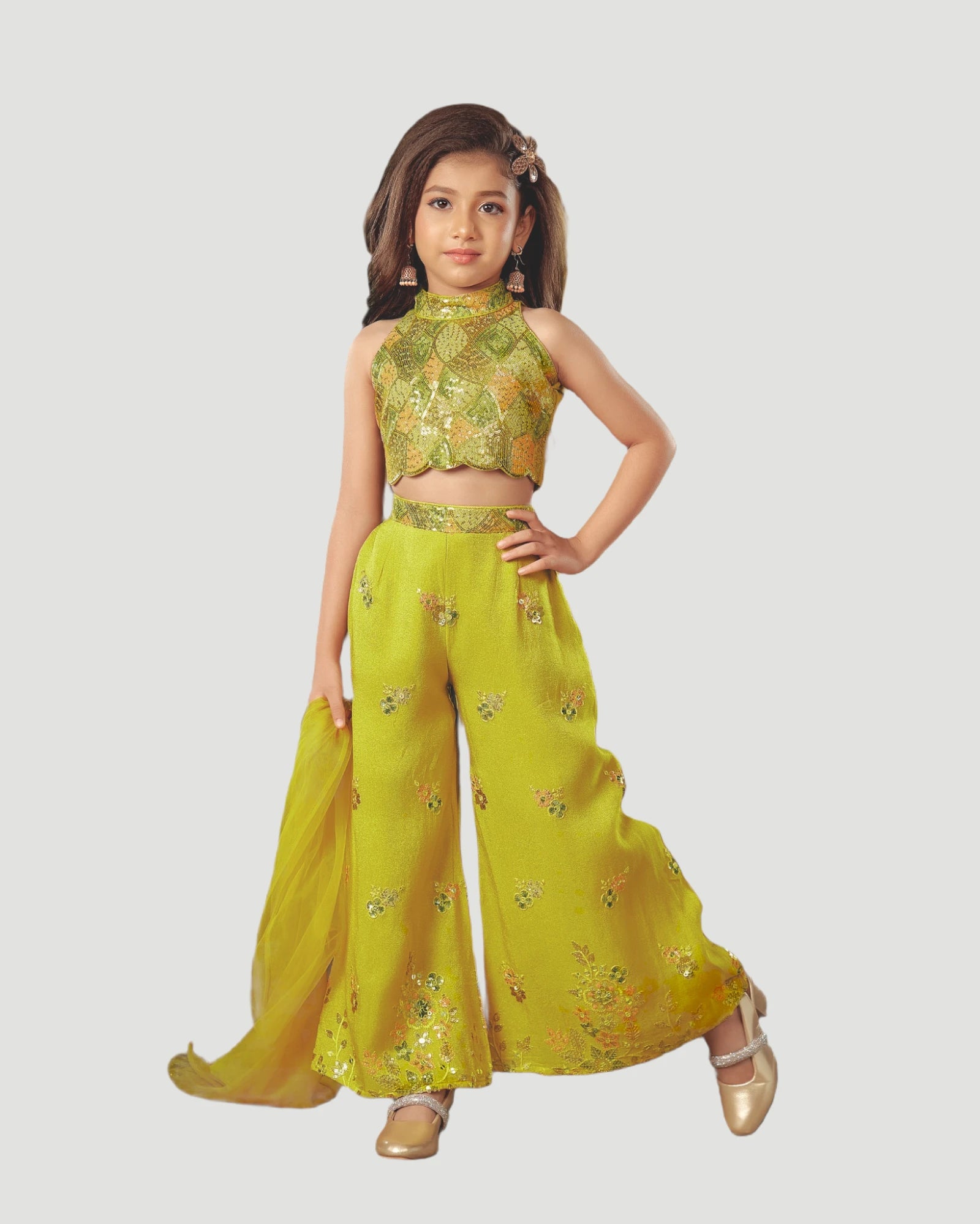 Young girl wearing a yellow traditional outfit with floral patterns on a white background