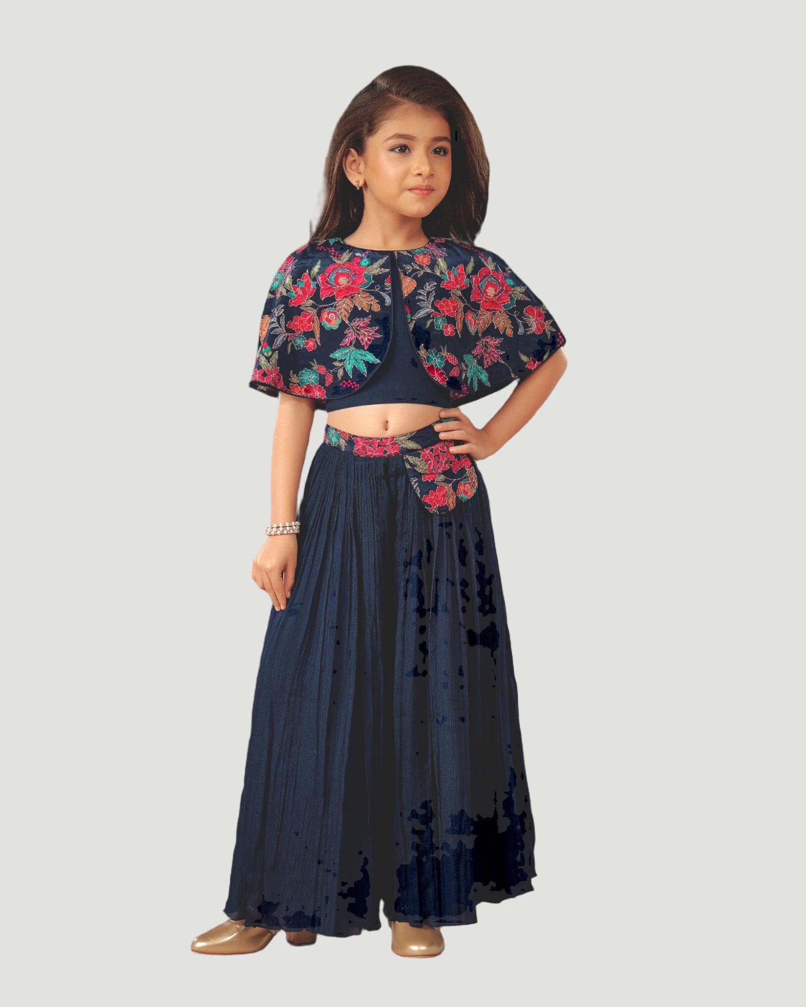 Young girl wearing a dark blue traditional outfit with floral patterns on a white background