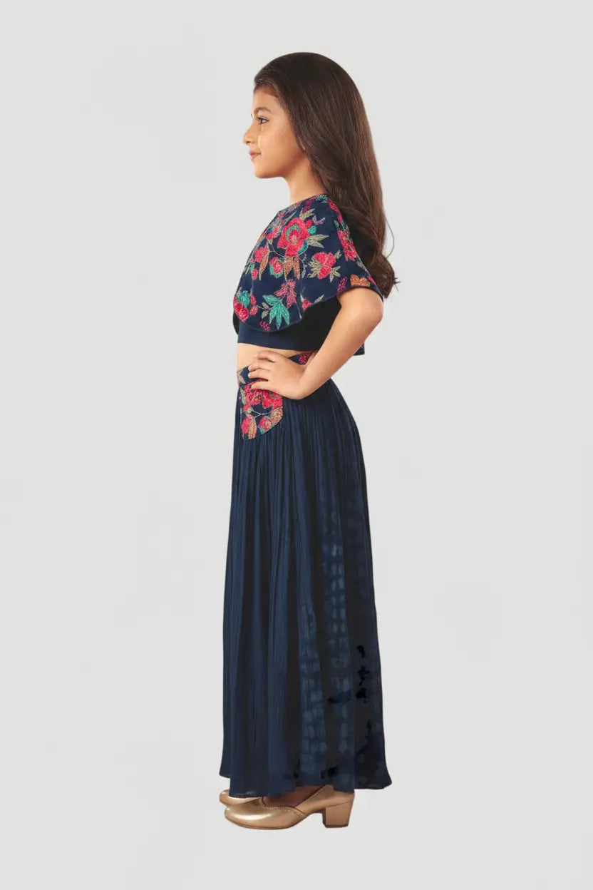 Woman wearing a navy blue saree with floral blouse on a white background
