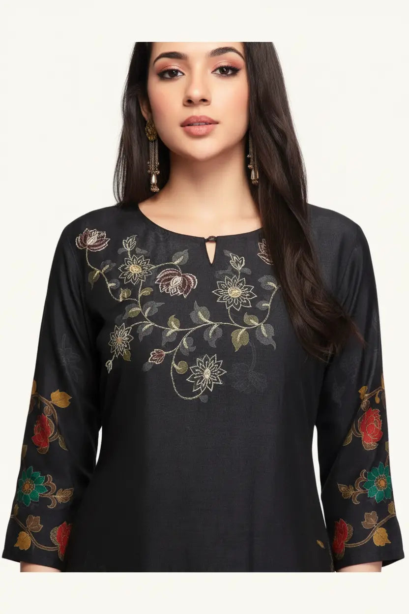 Black top with floral embroidery worn by a model on a white background