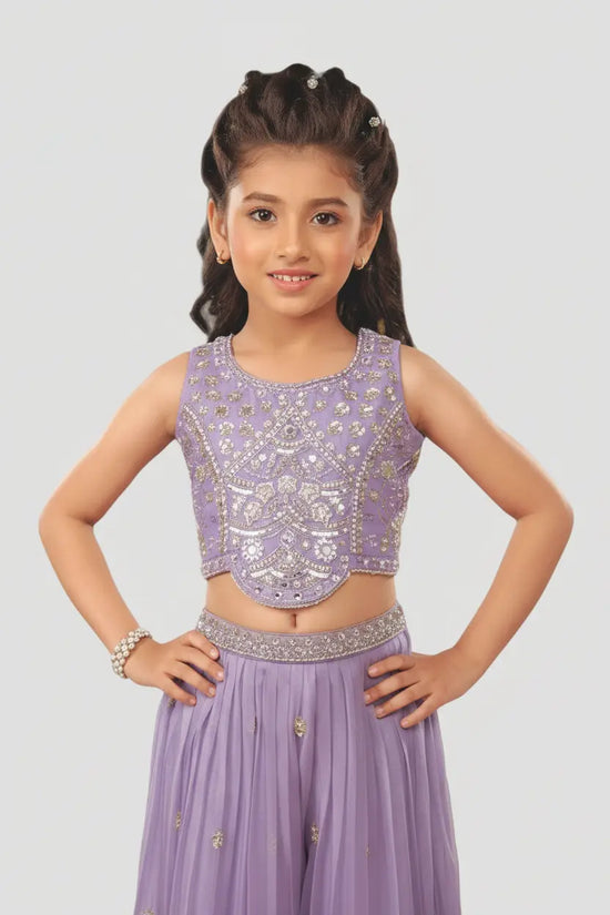 Young girl wearing a purple traditional outfit with intricate designs on a light gray background