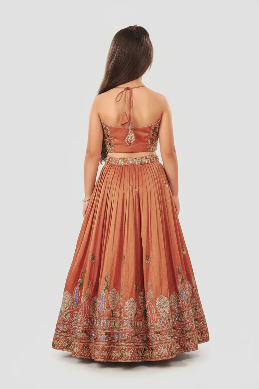Woman wearing a rust-colored dress with intricate patterns on a white background