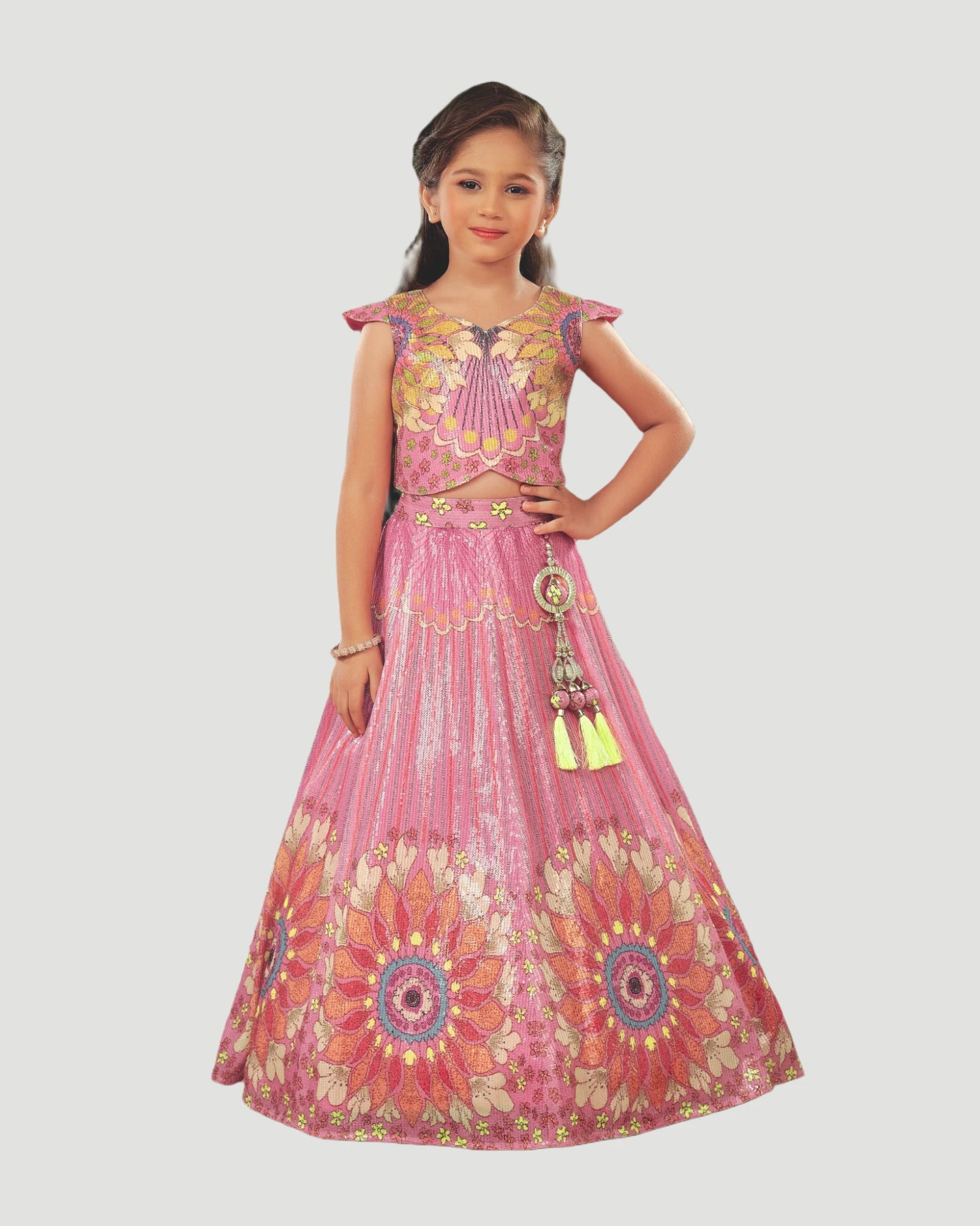 Young girl wearing a pink and yellow traditional outfit on a white background