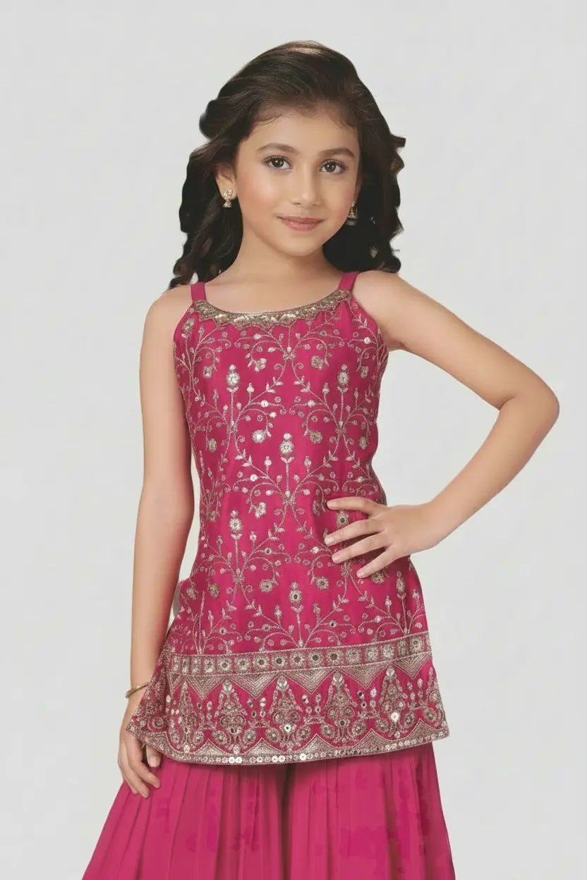 Young girl wearing a pink traditional outfit with intricate designs on a white background