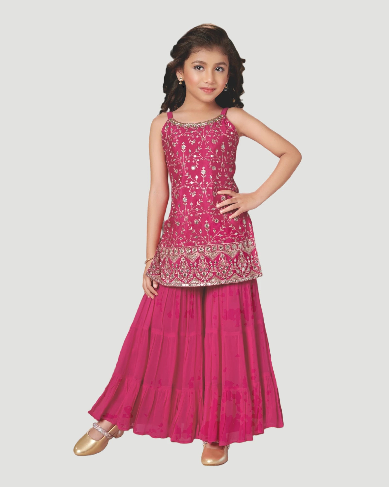 Young girl wearing a pink traditional outfit with intricate designs on a white background