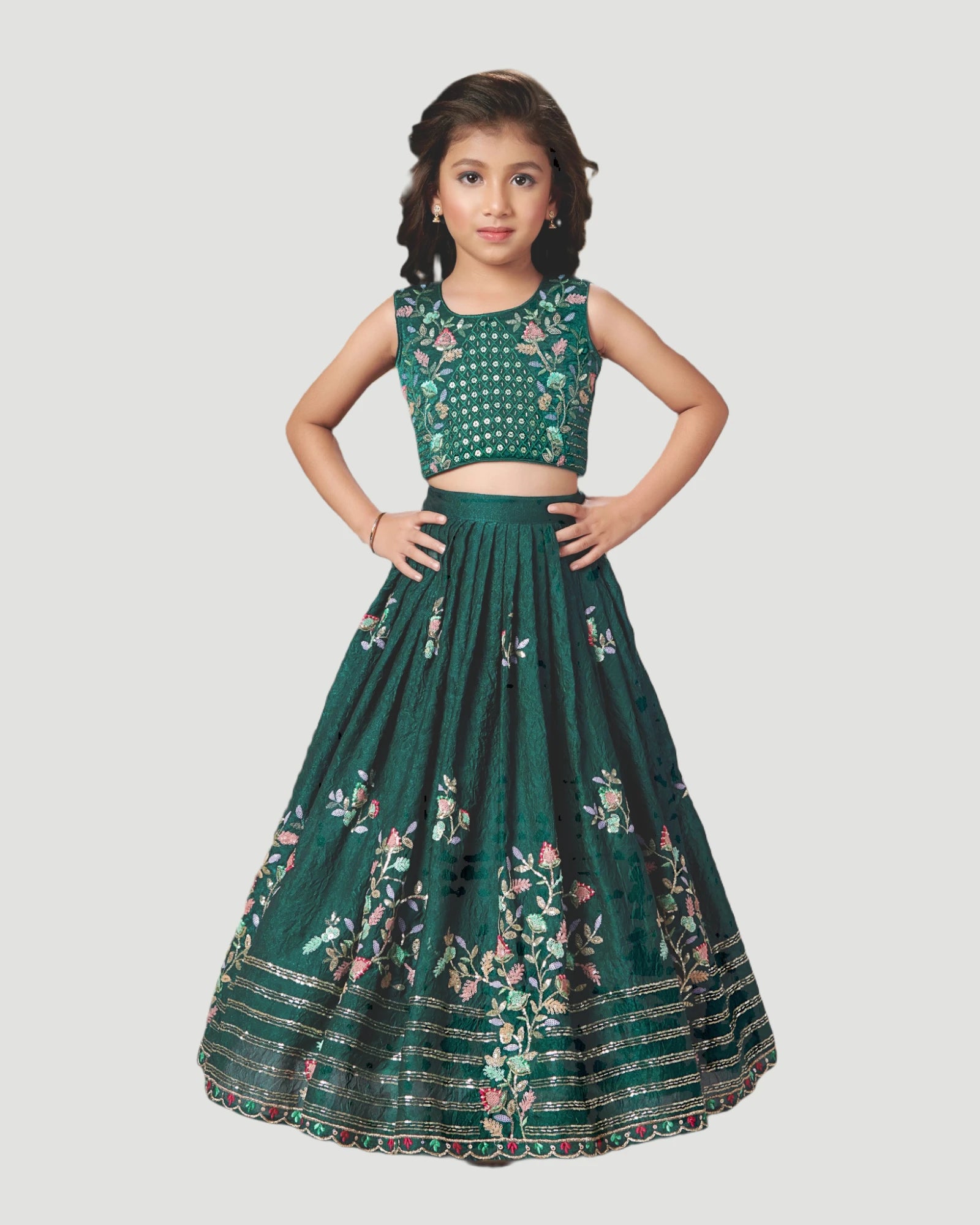 Young girl wearing a green embroidered traditional outfit on a light gray background