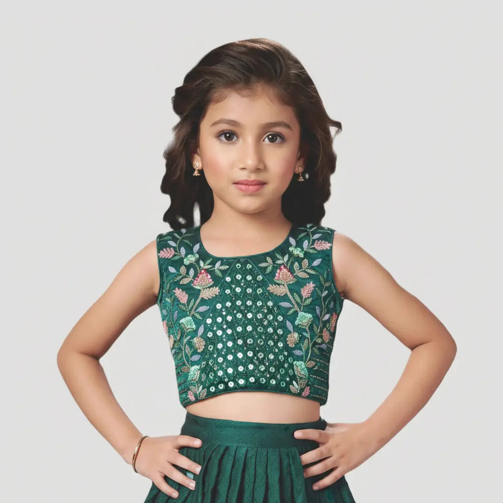 Young girl wearing a green embroidered top and skirt on a white background