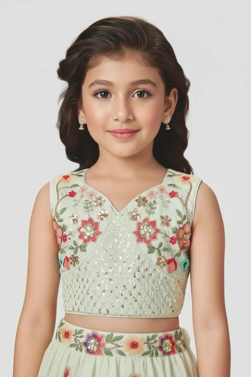 Young girl wearing a floral embroidered outfit on a plain background