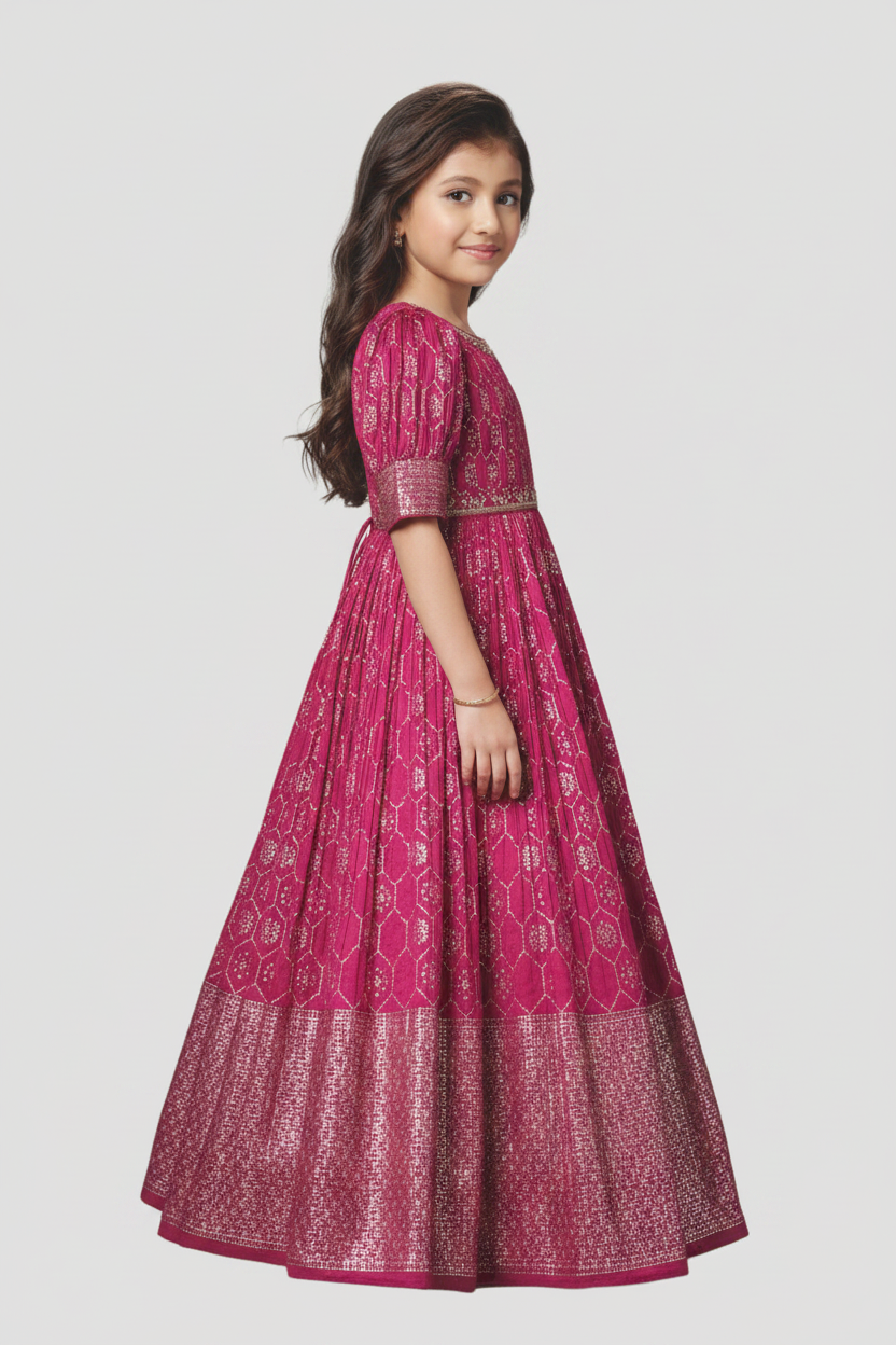 Young girl wearing a pink traditional outfit with intricate patterns on a white background