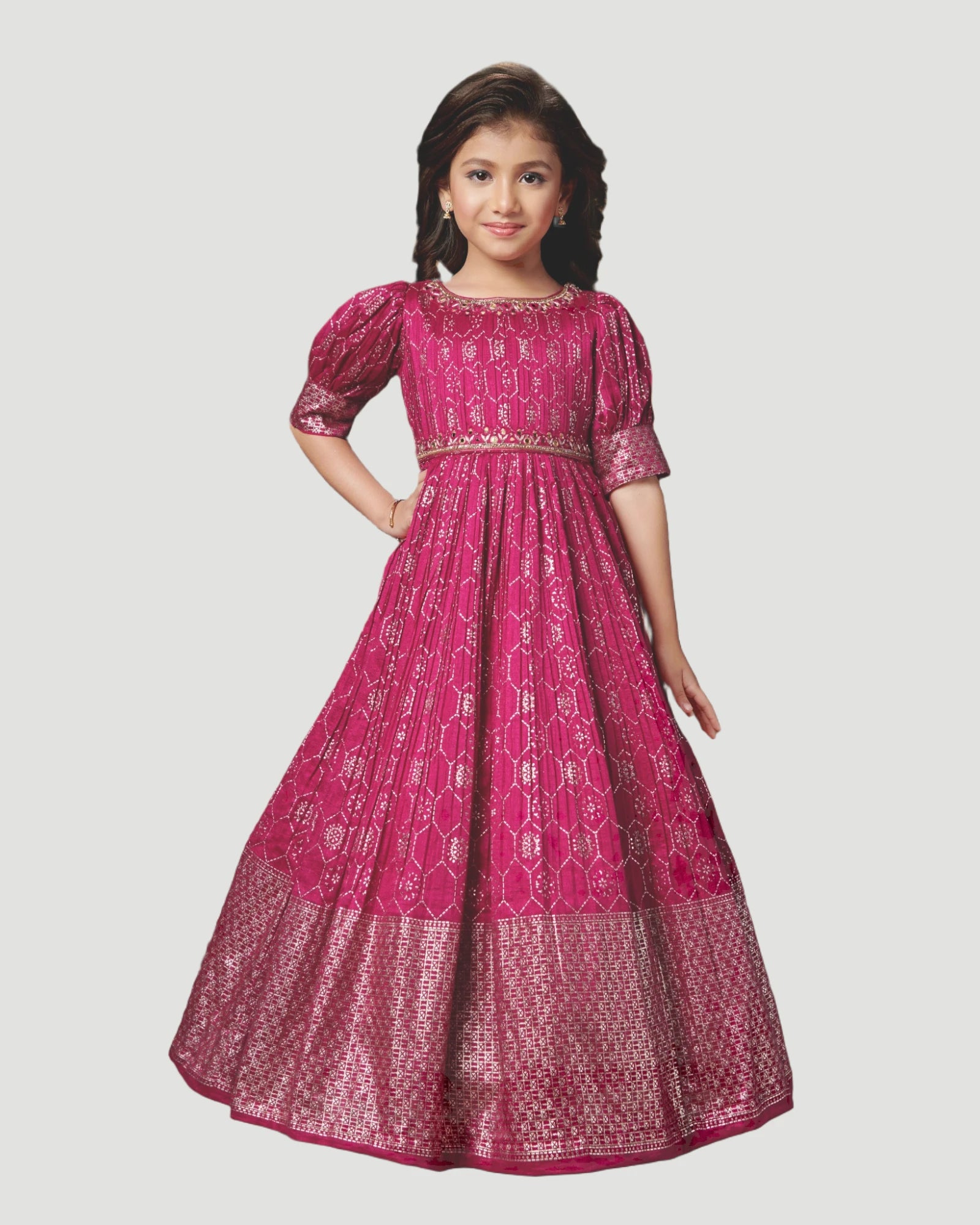 Young girl wearing a pink traditional dress with intricate patterns on a white background