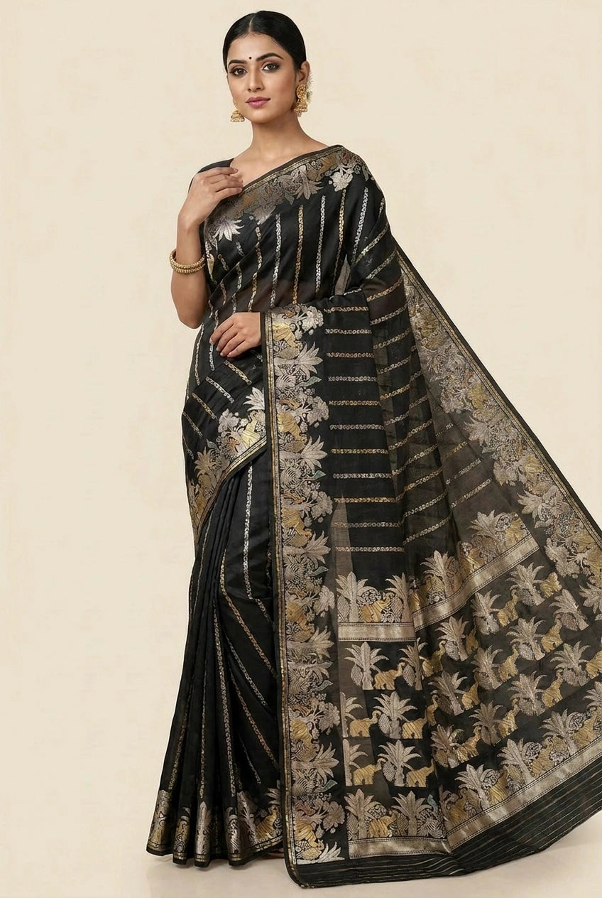 Woman wearing a black saree with gold patterns on a beige background