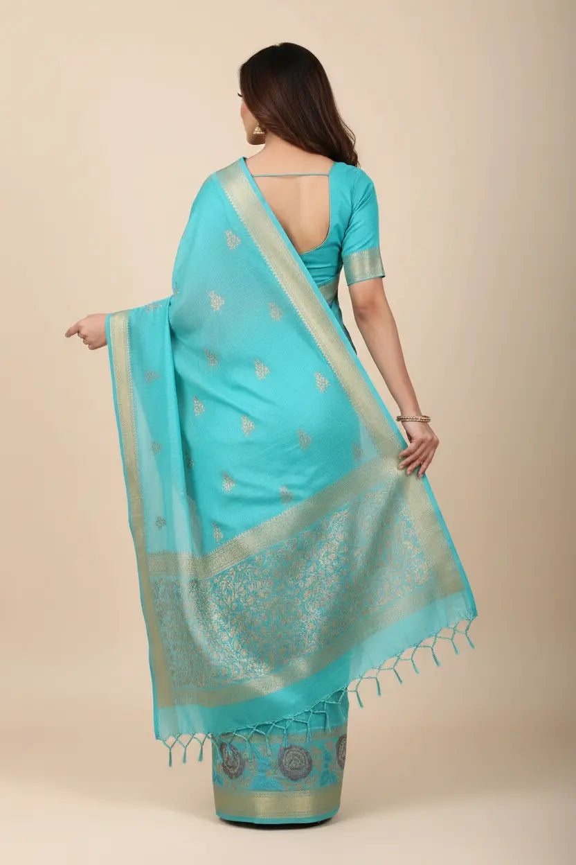 Woman wearing a turquoise saree with a beige background