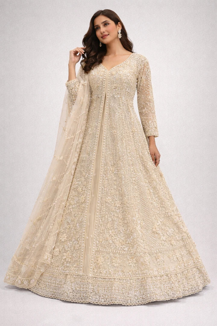 Woman wearing a beige embroidered anarkali suit on a white background