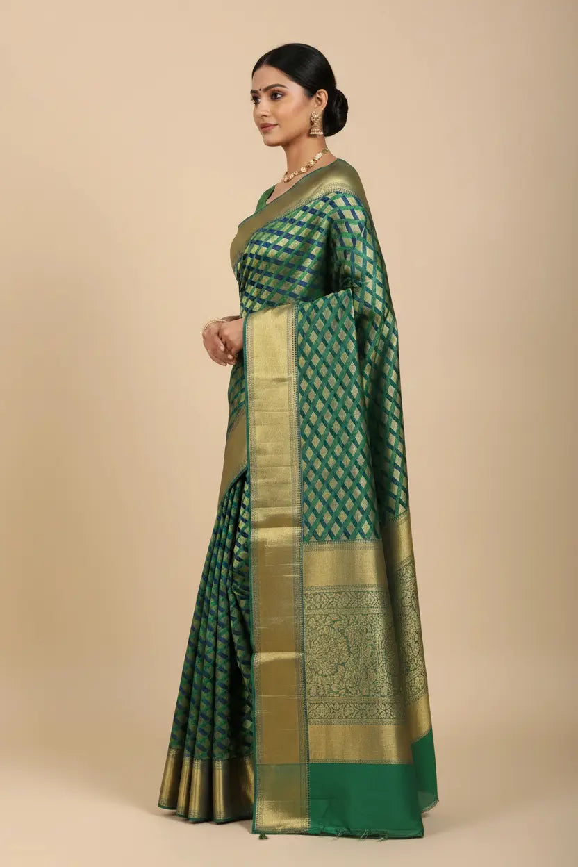 Woman wearing a green saree with a gold border on a beige background