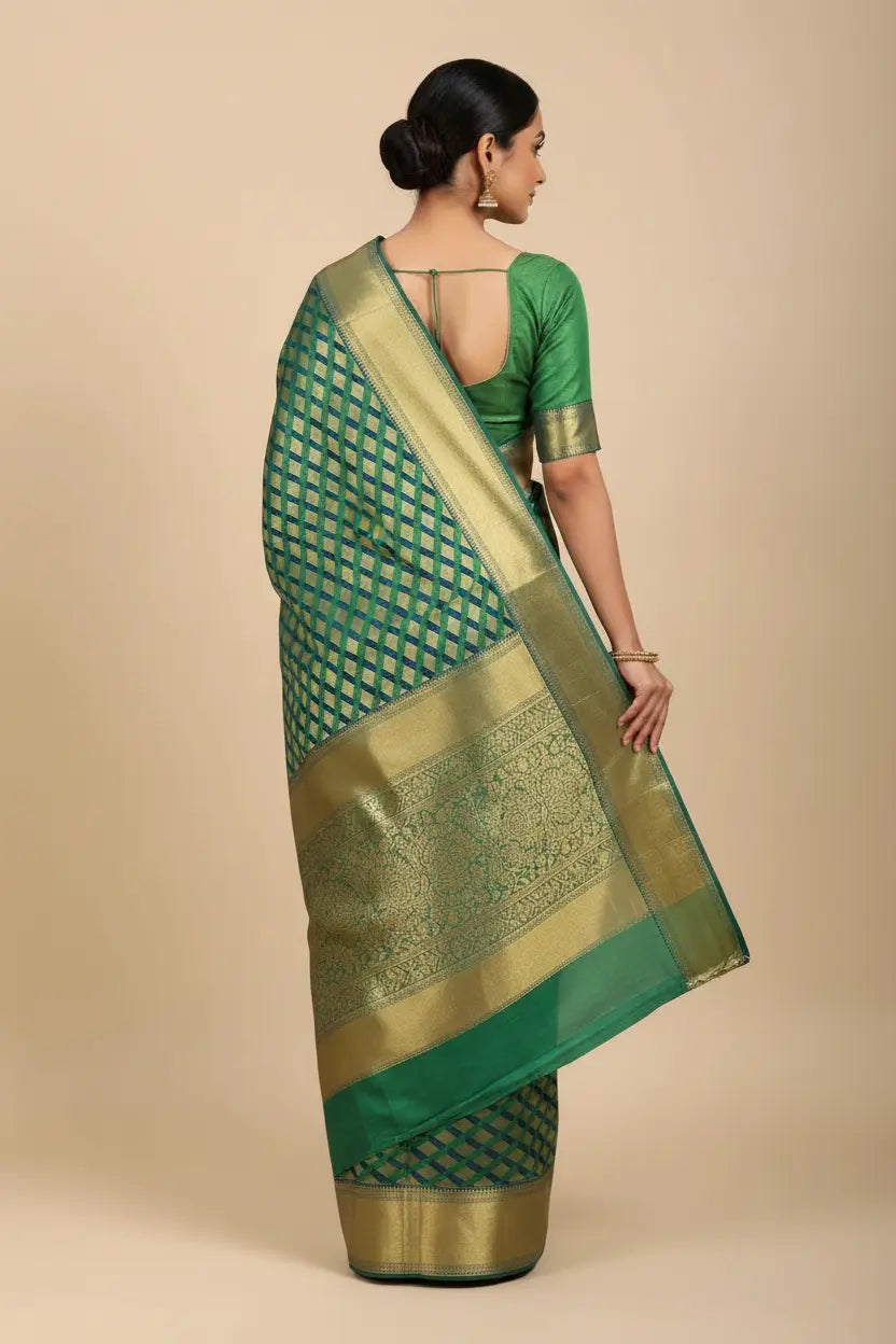 Woman wearing a green saree with gold border on a beige background