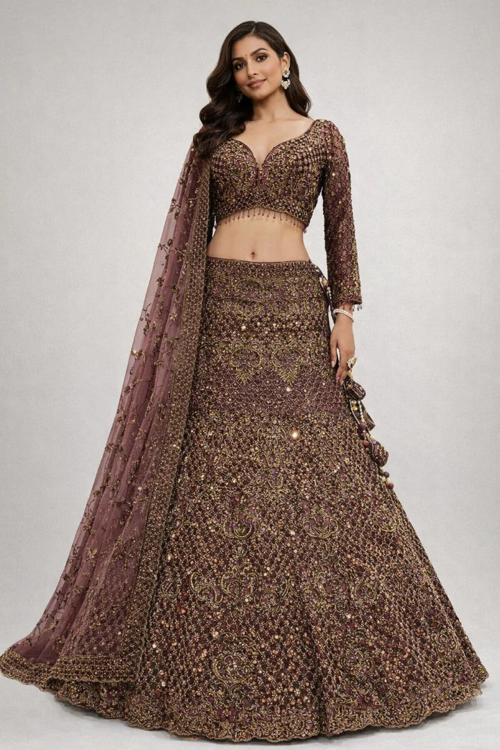 Woman wearing a traditional brown embroidered outfit with a matching dupatta on a plain background