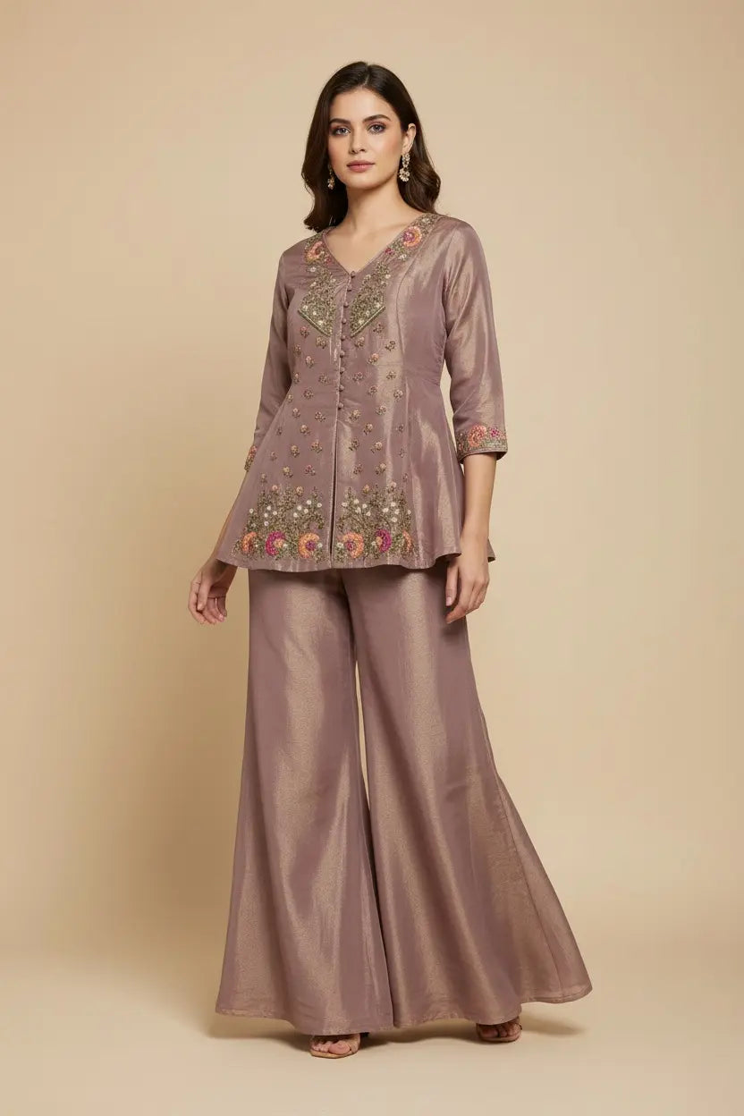 Woman wearing a mauve embroidered outfit on a beige background