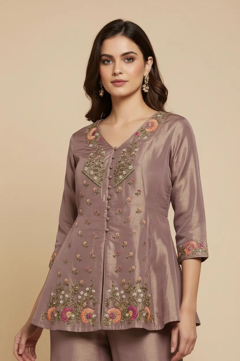 Woman wearing a brown embroidered top on a beige background