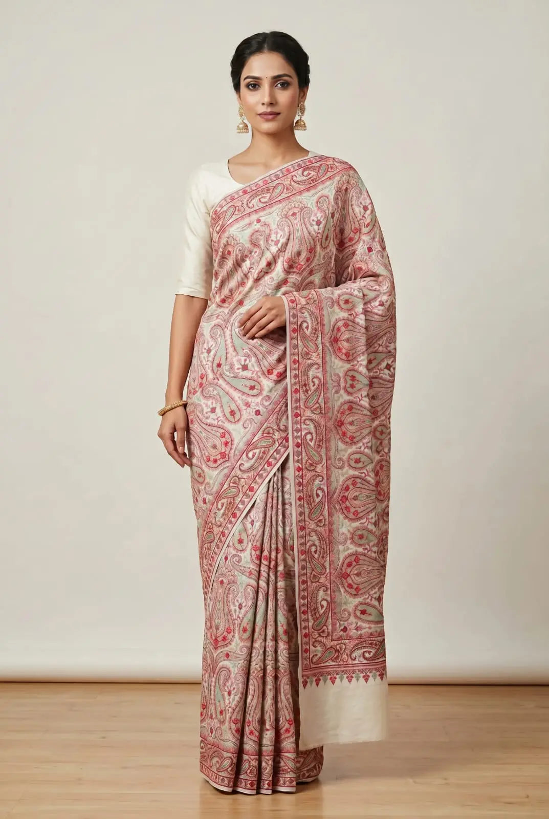 Woman wearing a traditional saree with a white and red pattern on a plain background
