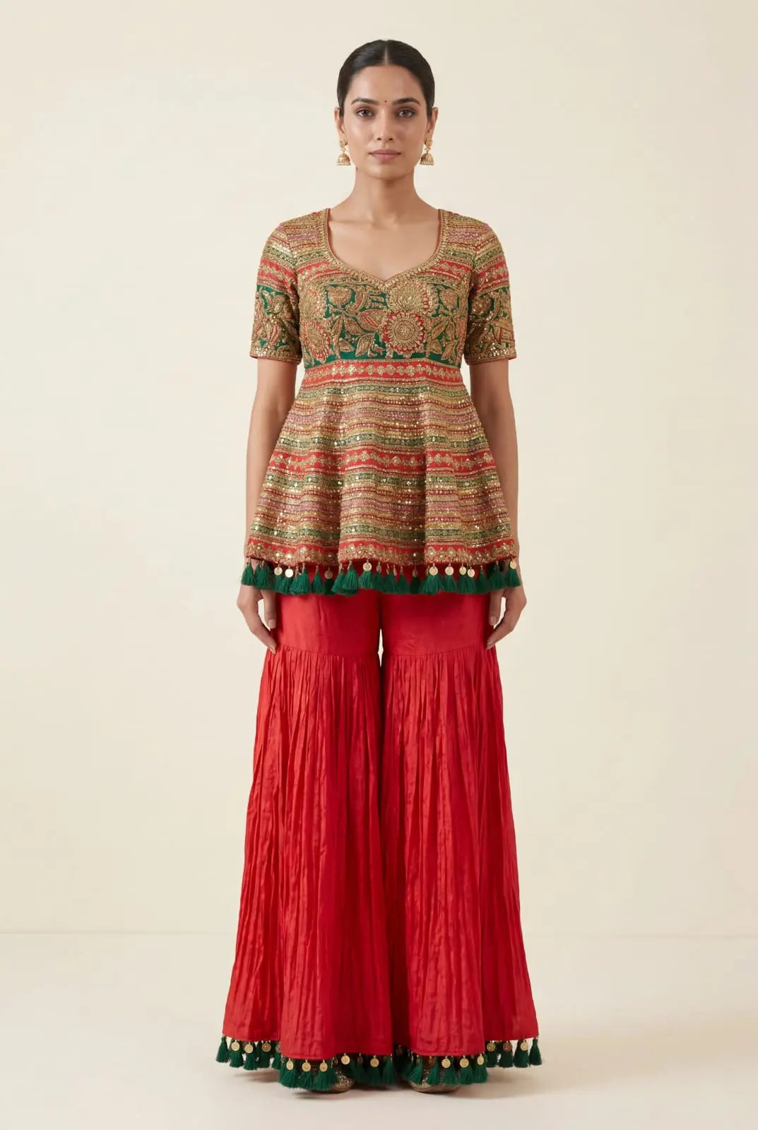 Woman wearing a patterned top and red pants on a beige background