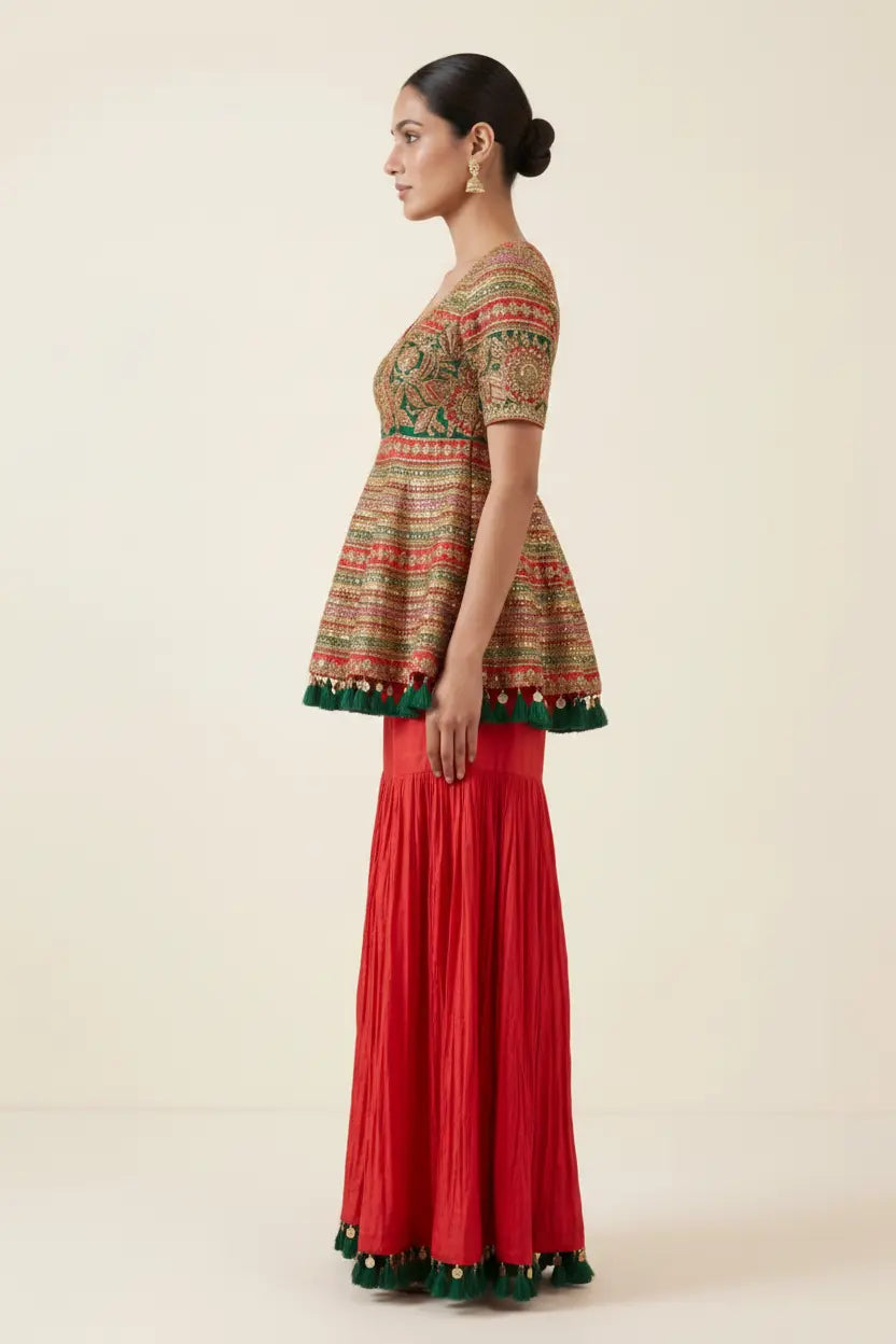 Woman wearing a patterned top and red skirt on a beige background