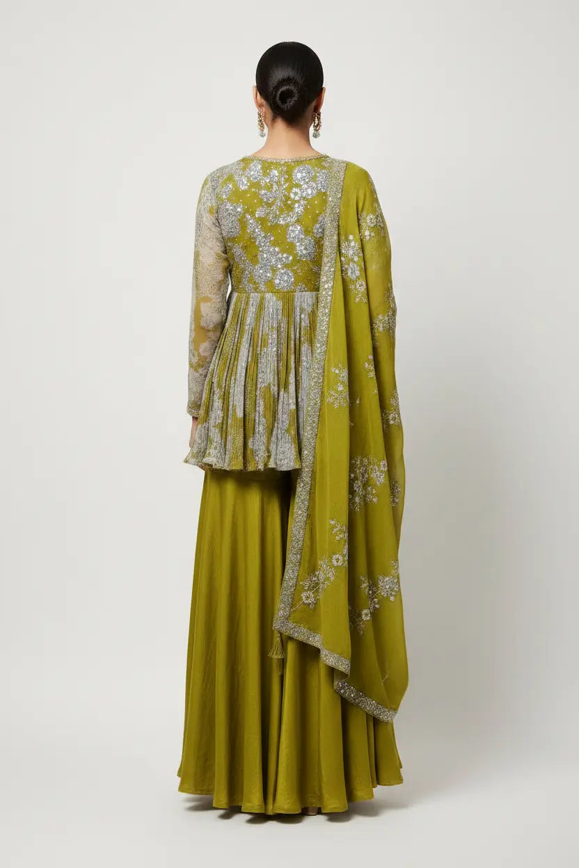 Woman wearing a green traditional outfit with floral patterns on a white background