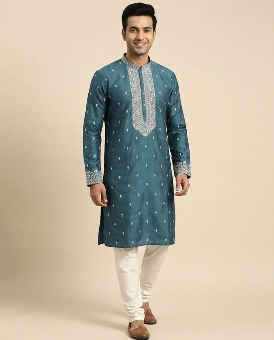 Model walking in the teal blue silk kurta with ivory churidar