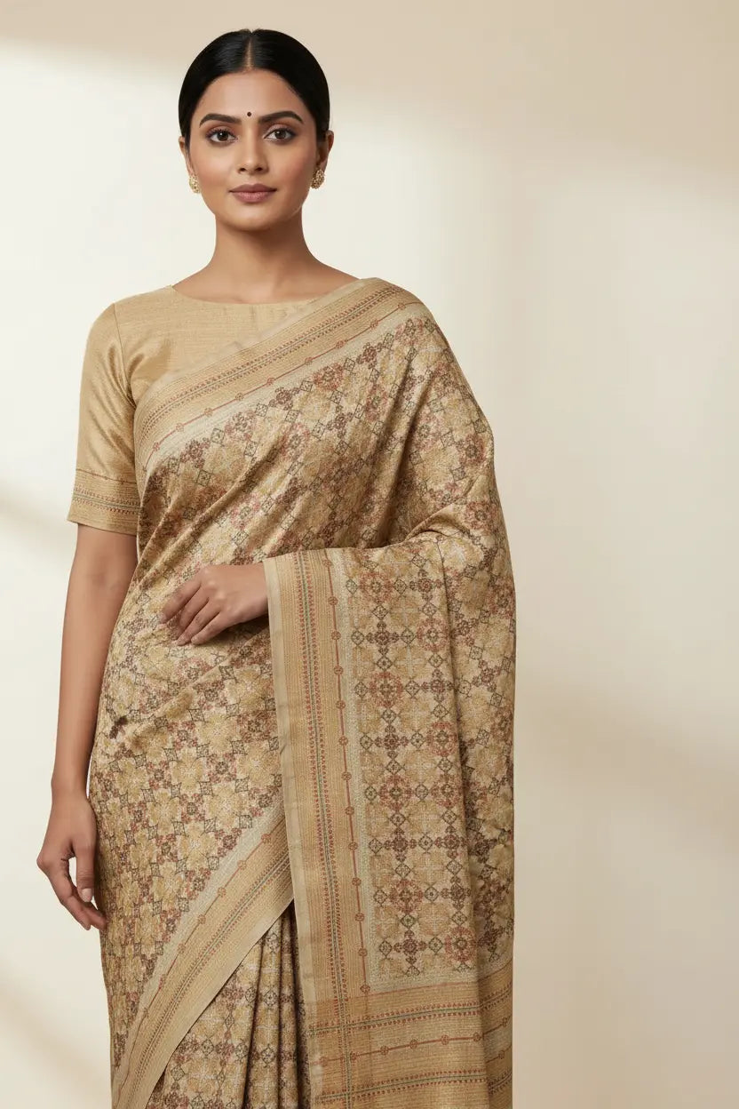 Woman wearing a beige saree with a subtle pattern on a plain background