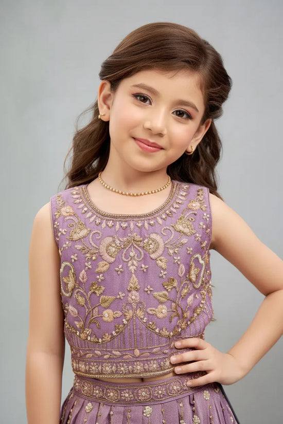 Young girl wearing a purple embroidered top against a gray background