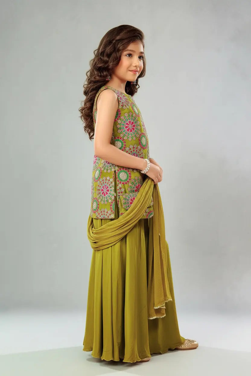 Young girl in a traditional outfit with a floral top and green skirt on a plain background