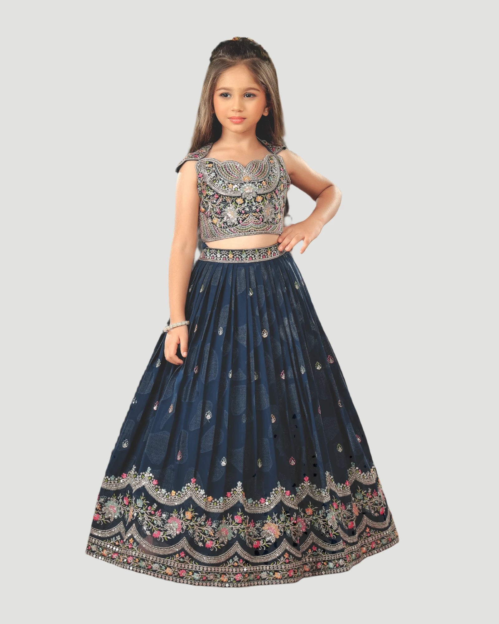 Young girl wearing a traditional embroidered outfit on a plain background