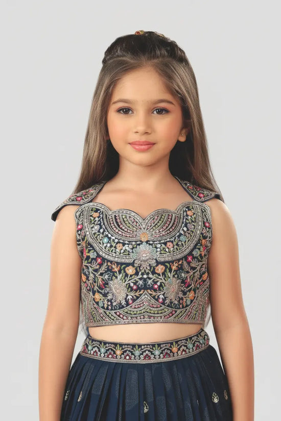 Young girl wearing a traditional embroidered top and dark skirt on a light gray background