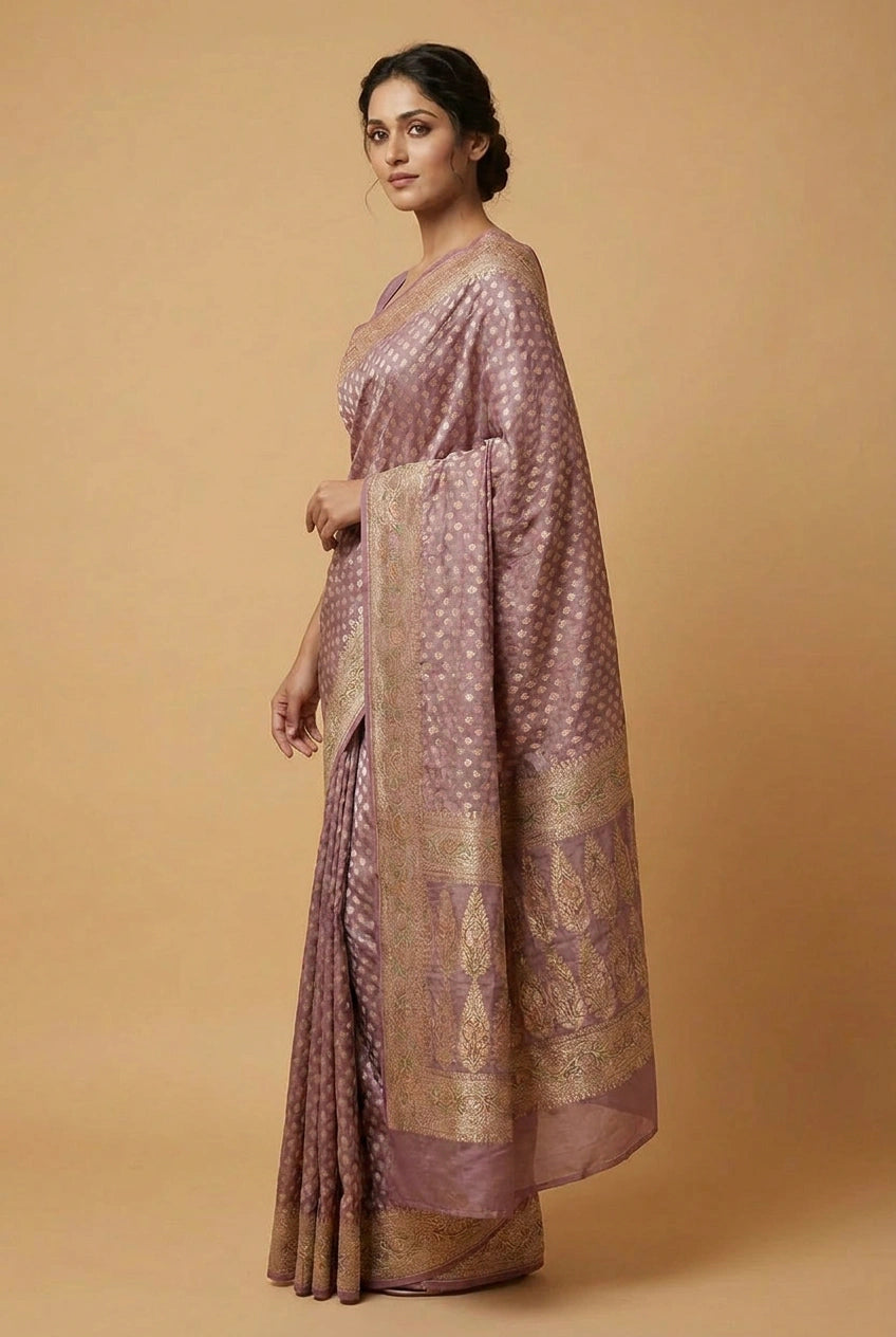 Woman wearing a traditional saree with a gold border on a beige background