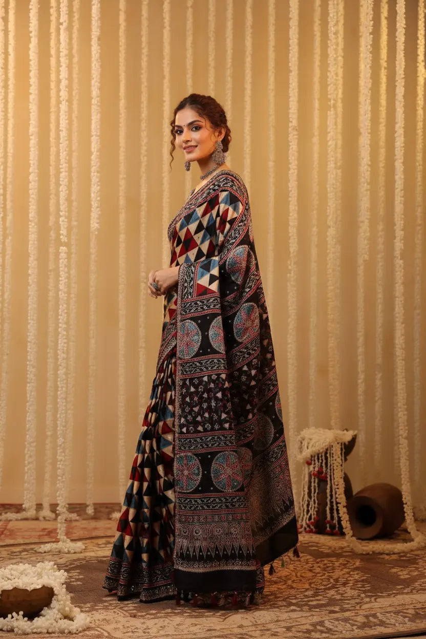 Woman in a traditional patterned dress standing against a textured beige wall.