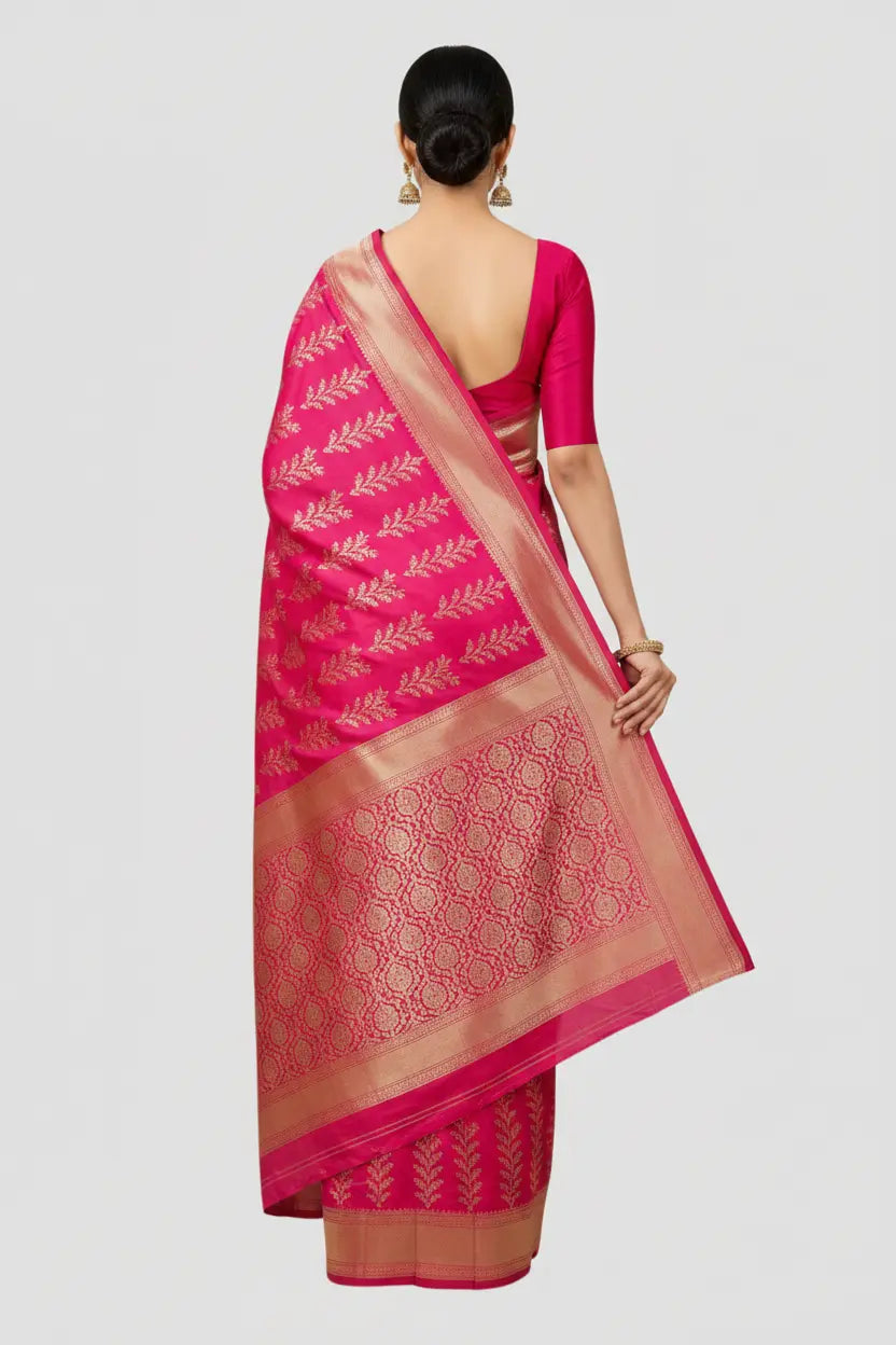 Woman wearing a pink saree with a white blouse on a light gray background
