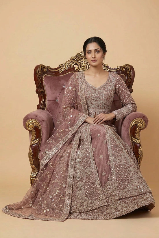 Woman in a traditional embroidered outfit sitting on an ornate chair against a beige background