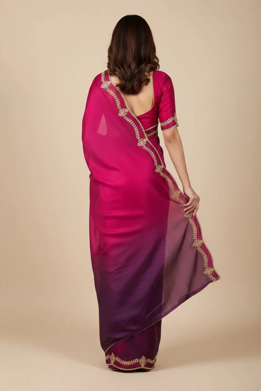 Woman wearing a pink saree with gold border on a beige background