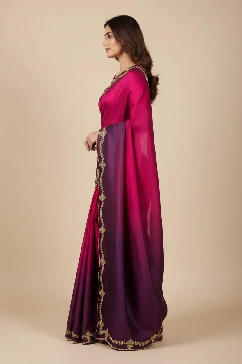 Woman wearing a pink and purple saree with gold border on a beige background