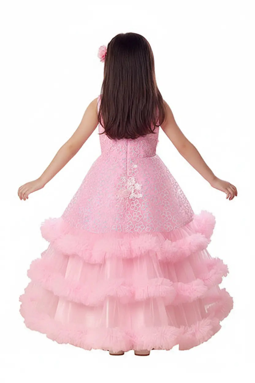 Young girl wearing a pink dress with a layered skirt and sequin bodice on a white background