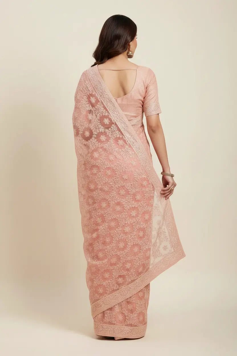 Woman wearing a pink saree with a white background