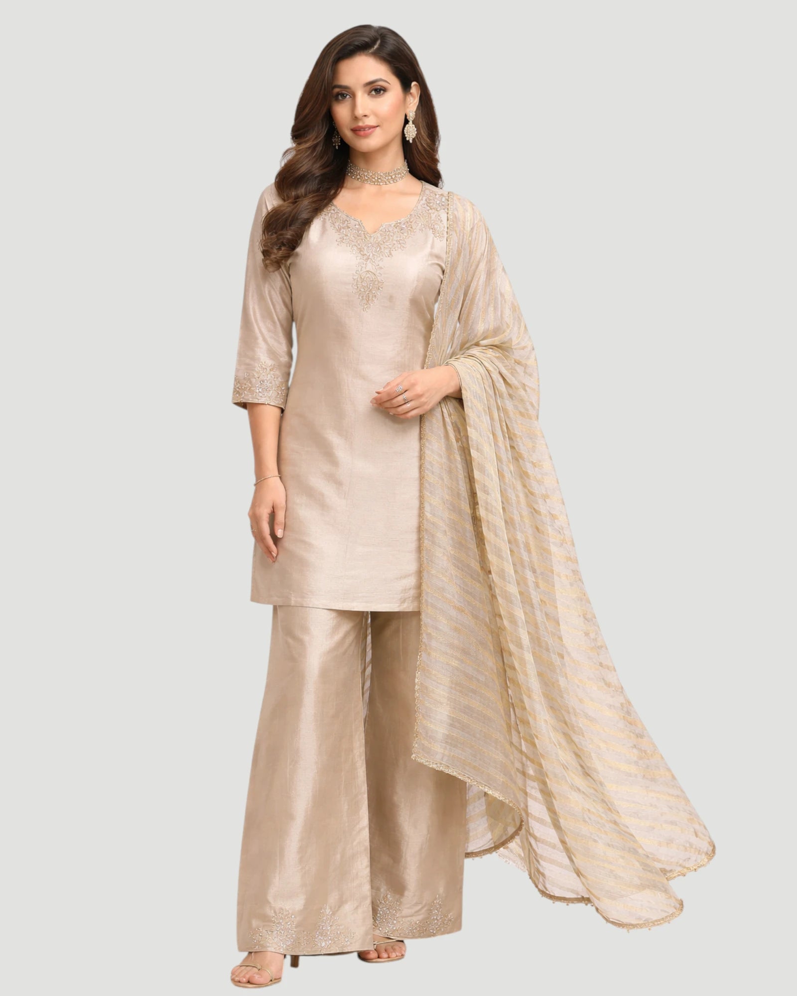 Woman wearing a beige traditional outfit with a dupatta on a light gray background