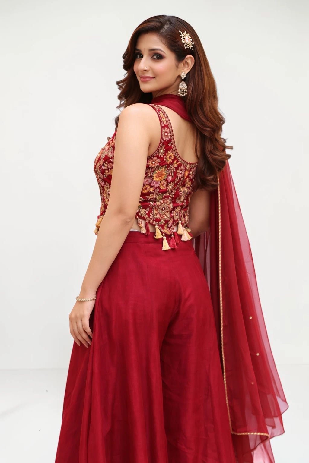 Woman wearing a red floral top and red pants with a matching dupatta on a white background