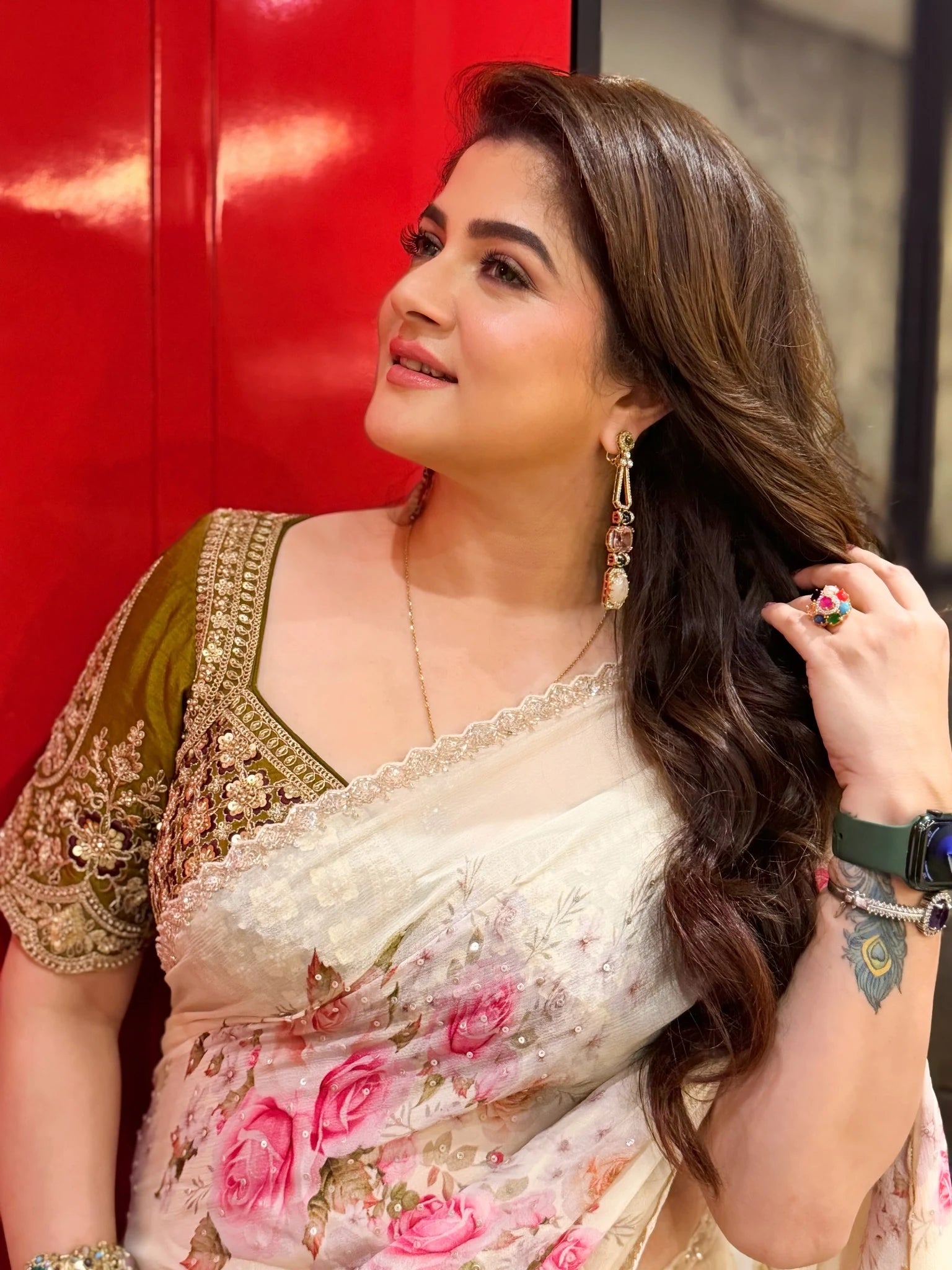 Woman in a floral saree with a red background