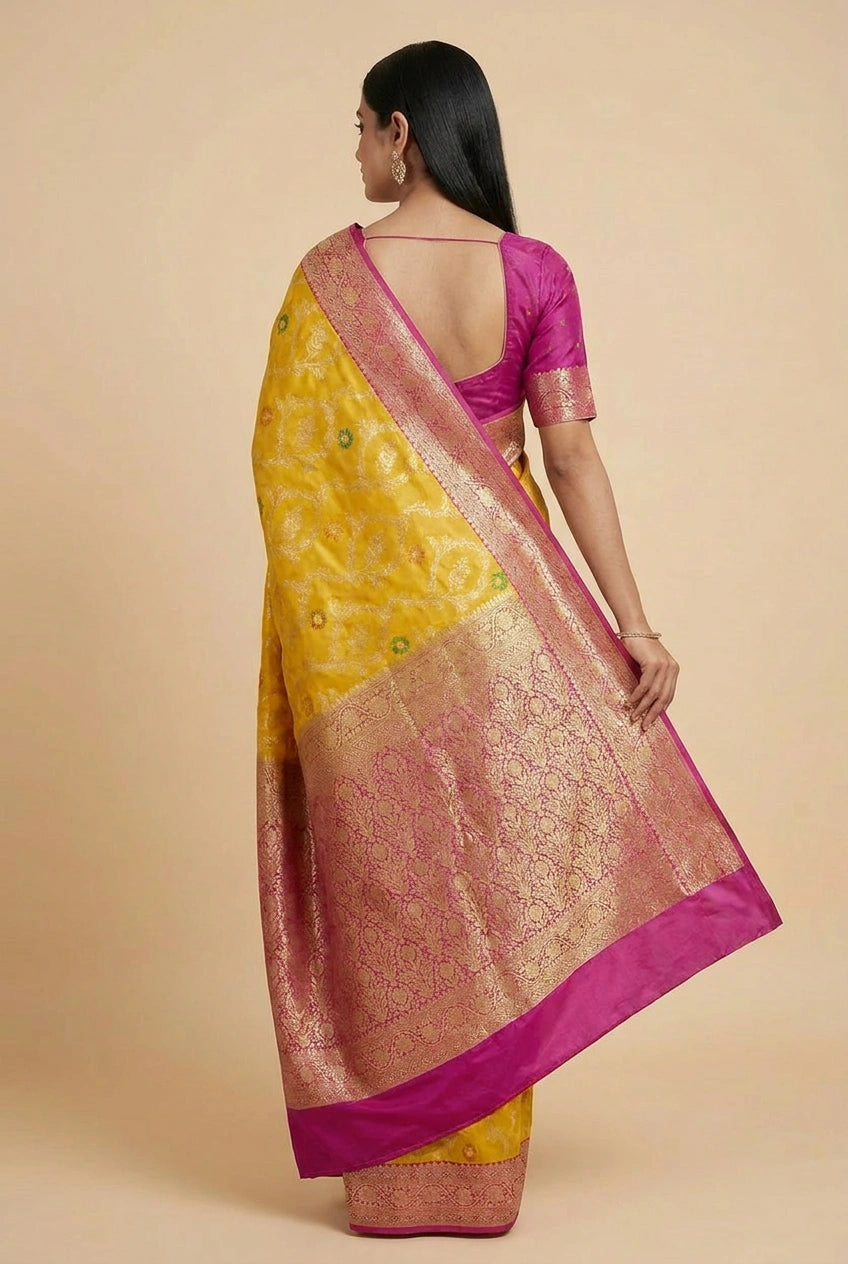 Woman wearing a yellow and pink saree with a beige background
