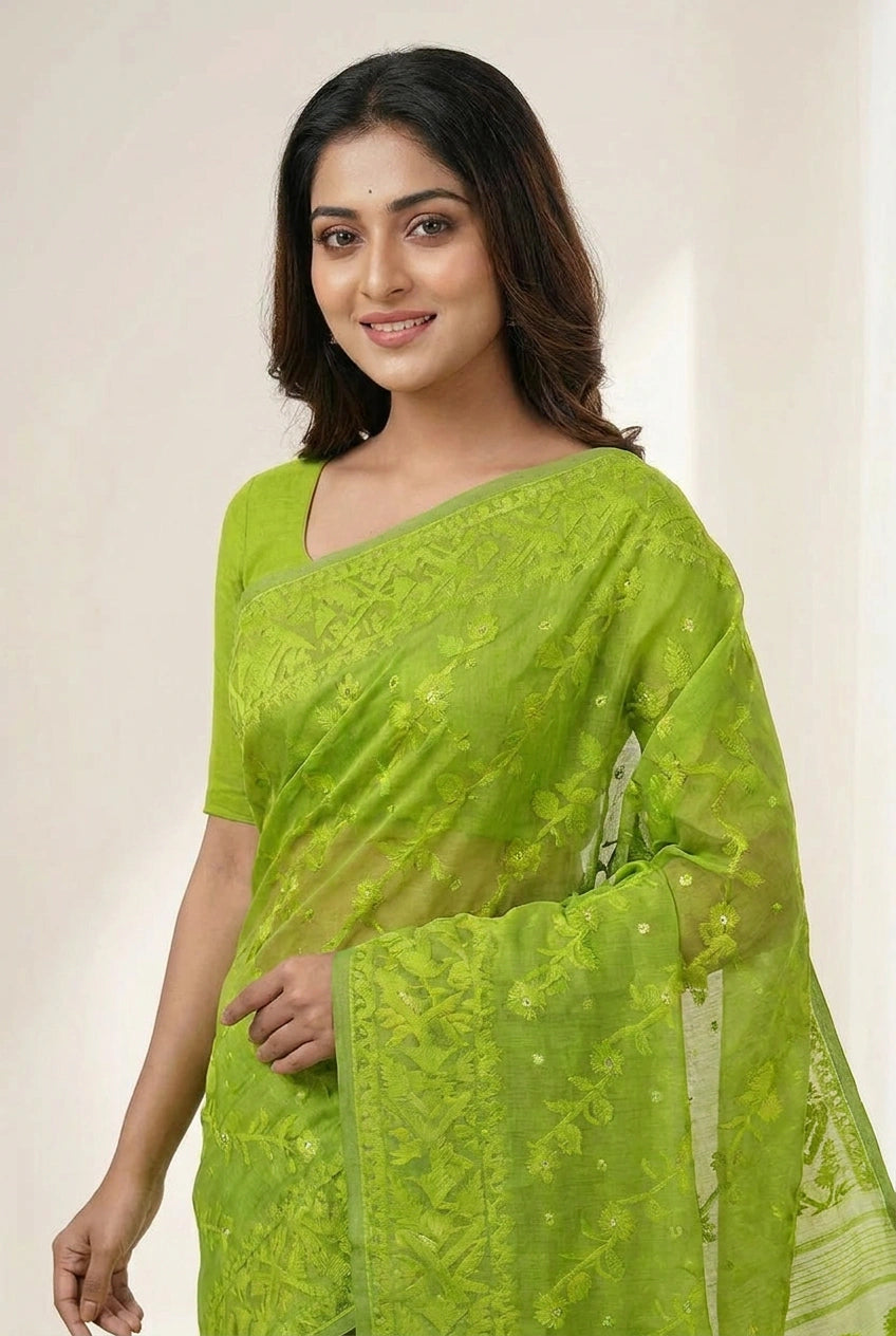 Woman wearing a green saree with a plain background