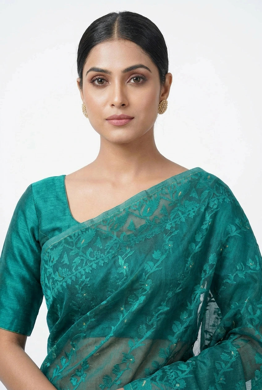 Woman wearing a teal saree with a white background