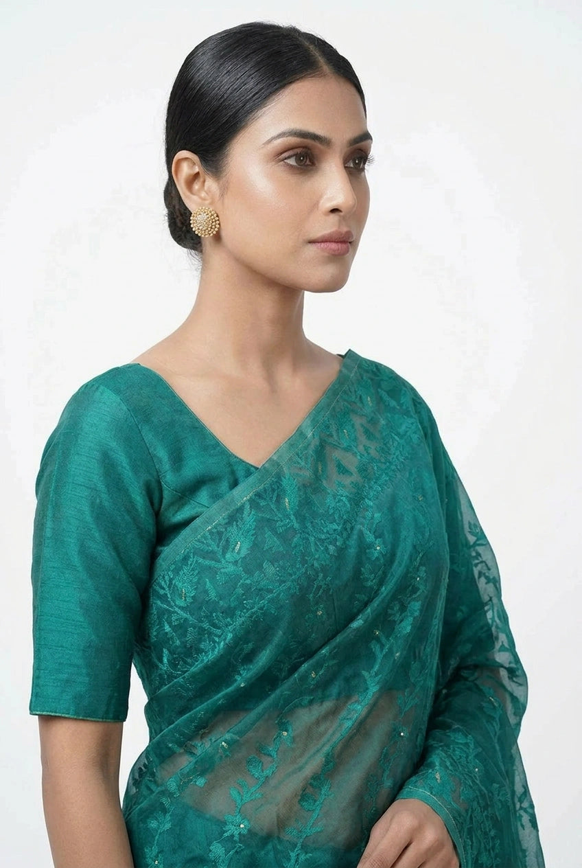 Woman wearing a teal saree with a white background