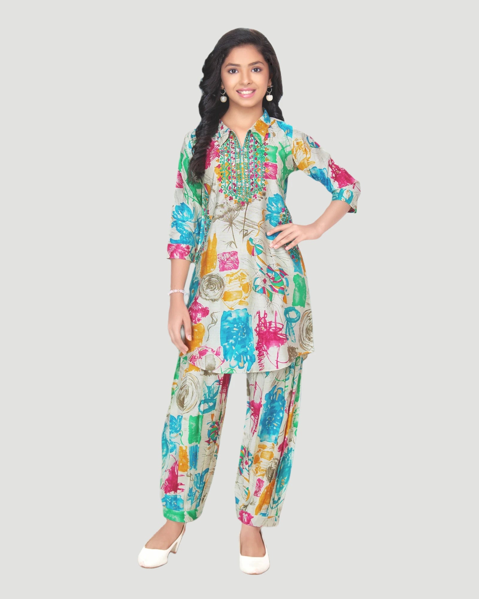 Woman wearing a colorful patterned outfit on a gray background