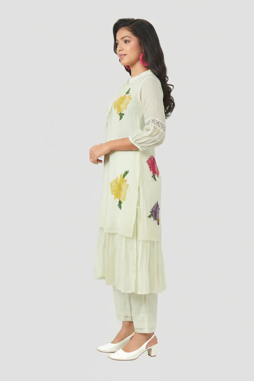 Woman wearing a light green embroidered outfit on a white background