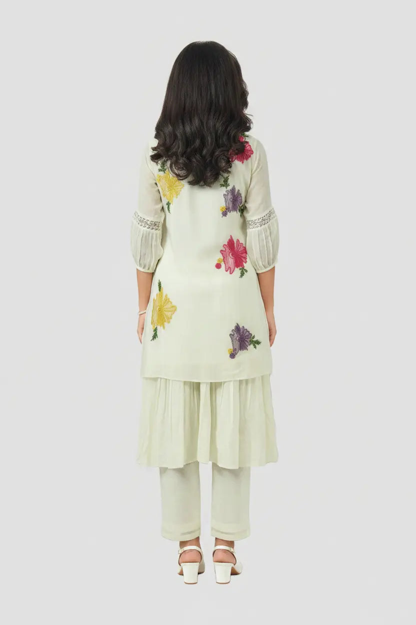 Woman wearing a floral embroidered outfit on a white background